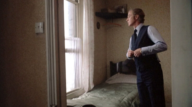 get-carter_michael-caine-blue-suit-waistcoat-buttoning_side-7477189